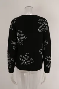 Back view of women's black plus size knit sweater featuring white floral patterns