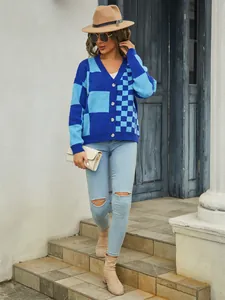 Stylish woman wearing blue checkered knit cardigan with ripped jeans and a classic brown hat