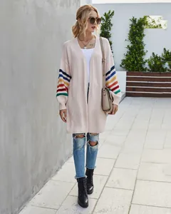 Vue détaillée d'un gilet rose surdimensionné pour femme avec manches rayées arc-en-ciel.