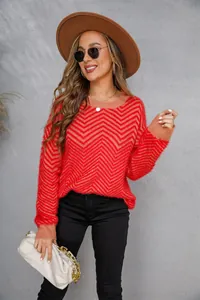 Detail view of the vibrant red and tan zigzag pattern on a fuzzy crewneck sweater