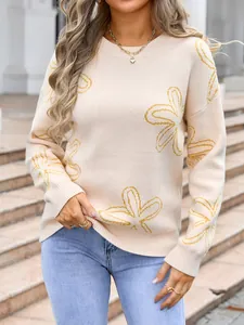 Detail view of the elegant cream-colored knitted sweater with yellow floral pattern