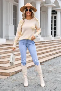 Detailed view of women's beige knit sweater with vibrant yellow floral line art patterns