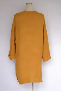 Rückansicht mit Textur eines senfgelben, übergroßen, langen Strick-Cardigans.