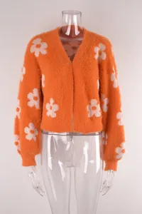 Cárdigan de punto naranja con flores de tacto suave en un maniquí transparente