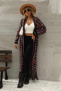 Full view of a colorful checkered long knit cardigan with tassel trim in a street style setting.