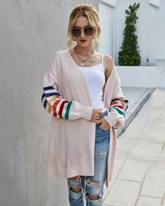 Détail d'un cardigan beige pour femme avec des rayures arc-en-ciel vives sur les manches