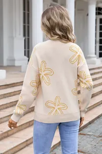 Detailed back view of a beige oversized knitted sweater with yellow floral prints.