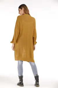 Rückansicht einer langen senfgelben Strickjacke für Damen, kombiniert mit Jeans und Stiefeln.