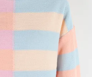 Close-up detail of soft pastel striped knit texture on women's pullover sweater