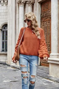 Stylish rust-colored chunky knit sweater featuring unique textured bubble sleeves and round neck
