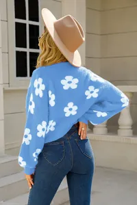 Vista trasera de un jersey de punto azul suave con grandes motivos de flores blancas