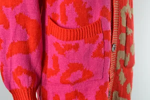 Close-up detail of the vibrant pink and orange leopard print knitted cardigan texture.