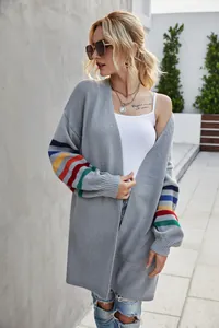 Détail du cardigan gris en maille avec manches rayées aux couleurs de l'arc-en-ciel.