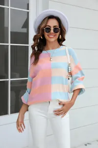 Detail shot of a pastel striped color-block crewneck knit sweater for women.