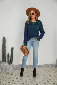 Full body shot of a woman in a chevron knit sweater with casual denim and a felt hat.