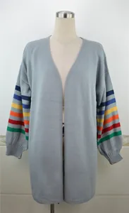 Détail de face d'un cardigan en maille ample avec manches à rayures arc-en-ciel