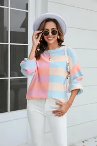 Model wearing a chic pastel color block striped round neck knit sweater outdoors.