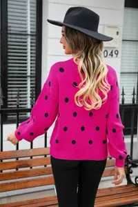 Back view of hot pink polka dot oversized knit sweater for women in outdoor street style