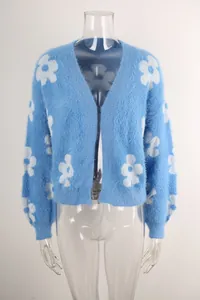 Detalle de un cárdigan de punto azul claro con suaves patrones de flores blancas