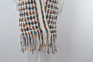 Close-up detail of the knit texture and long fringe hem on this plus size plaid cardigan