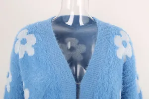 Primer plano de cárdigan azul peludo con diseño de flores blancas y tejido suave