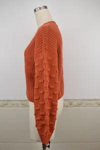 Side view of orange chunky knit sweater with textured bubble sleeves and cropped fit.