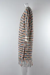 Side view of a long knit cardigan with colorful geometric patterns and tassels.