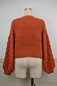 Back view of orange cropped knit sweater featuring oversized puff sleeves with popcorn texture