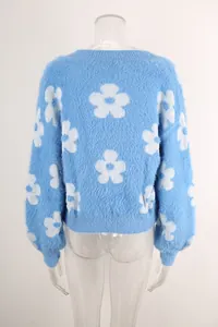 Vista trasera de la rebeca de punto azul suave con motivos florales blancos en maniquí