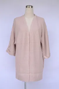 Detailansicht einer rosa Oversize-Strickjacke mit Rollärmeln auf einer Schaufensterpuppe.