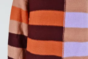 Close-up of the fine knit texture and colorful striped pattern of the women's sweater.