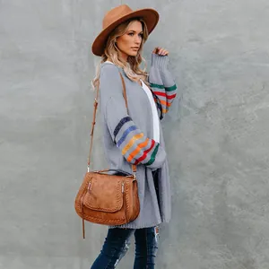 Vue détaillée du cardigan en maille grise avec des manches à rayures arc-en-ciel.