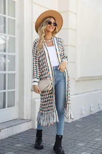 Detailed view of colorful plaid knit pattern and fringe tassels on a long cardigan