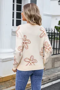 Detail back view of an off-white round neck sweater with stylish brown flower patterns