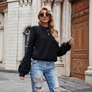 Stylish black knitted sweater with oversized balloon sleeves for a trendy street look.