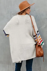 Vue détaillée du dos d'un cardigan en maille beige oversize avec manches à rayures