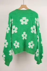 Vista detallada de un jersey de punto verde suave con grandes flores blancas