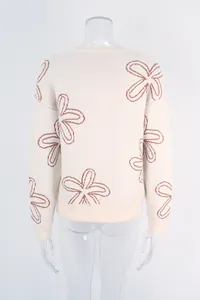 Detailed back view of a cream-colored floral knit sweater with long sleeves on a mannequin