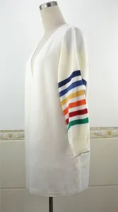 Vue latérale détaillée d'un gilet en tricot blanc avec des manches à rayures arc-en-ciel