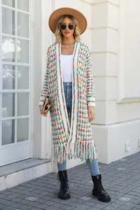 Detailed view of women's long knit cardigan with colorful plaid and fringe trim