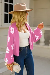 Detalle de un cárdigan rosa con flores combinado con vaqueros azules y sombrero.