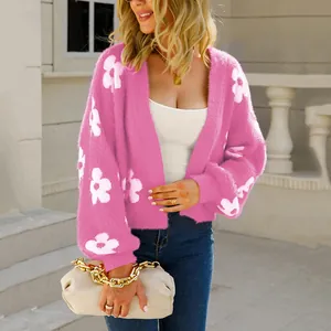 Vista detallada de una suave chaqueta de punto rosa con flores blancas de moda