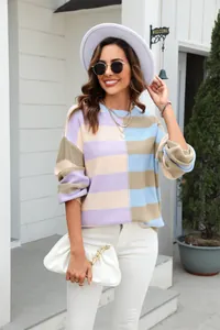 Model wears a vibrant color-block striped crew neck knit sweater in an outdoor setting.