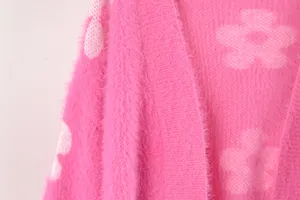 Detalle de cárdigan rosa peludo con motivo de flores blancas de punto
