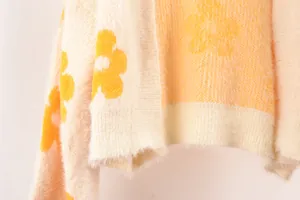 Detalle macro de cárdigan de punto amarillo suave con textura de patrón de flores