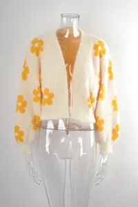 Detalle de un cárdigan corto de punto con estampado floral en maniquí de plástico.