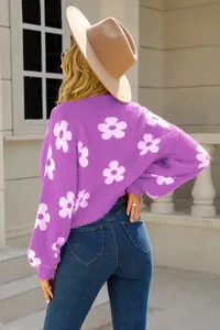 Vista trasera de un jersey de punto morado con flores blancas y una textura muy suave.