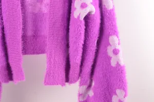 Primer plano de cárdigan de punto morado peludo con motivos florales blancos y textura