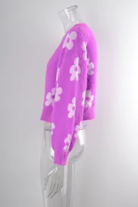 Detalle de perfil de cárdigan de punto peludo morado con motivos florales blancos en un maniquí