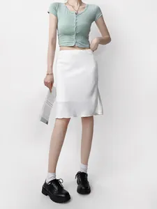 Vue complète d'une élégante jupe midi en satin blanc avec une taille haute.